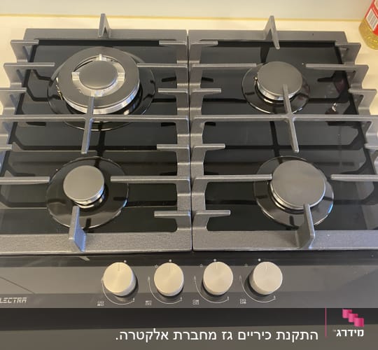 כיריים גז עם ארבעה מבערים וכפתורי שליטה